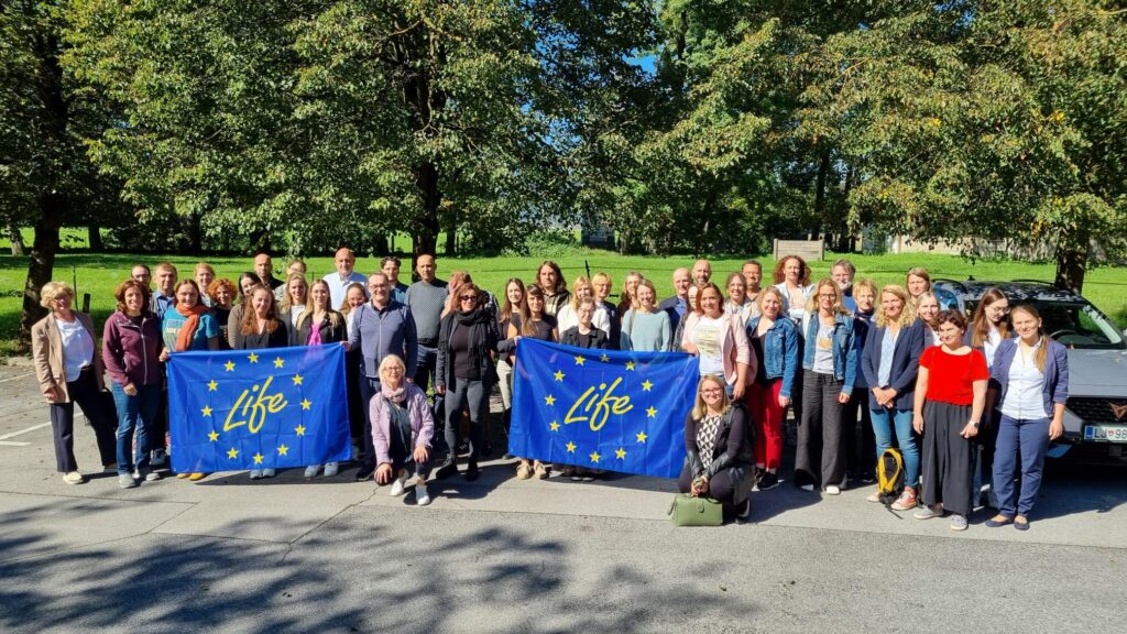 skupinska fotografija vseh partnerjev projekta LIFE4ADAPT, v ospredju zastava LIFE